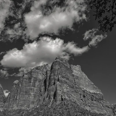 towering rock formation beneath dramatic cloudy sky