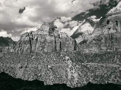 layered sandstone cliffs under dramatic cloudy sky