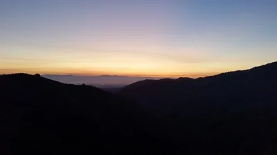 mountain silhouettes against sunset sky gradient
