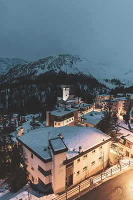 alpine resort town at dusk with snowy mountains