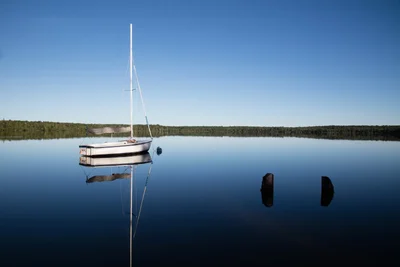 sailboat moored on calm lake morning