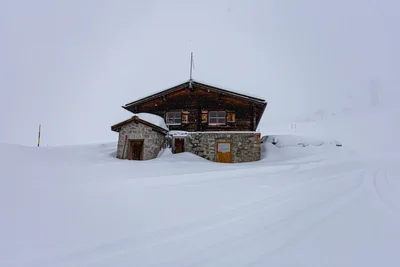 alpine cabin surrounded by deep winter snow