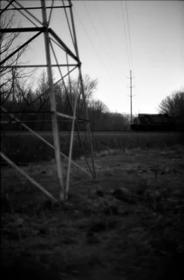 power lines cross rural field at dusk