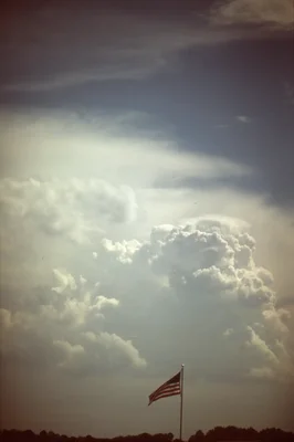 american flag beneath dramatic storm clouds