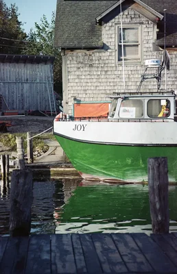 small boat named joy moored at wooden dock