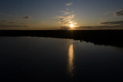 sunset over calm river with golden reflections