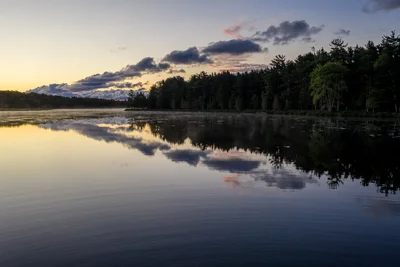 calm lake reflecting clouds at twilight
