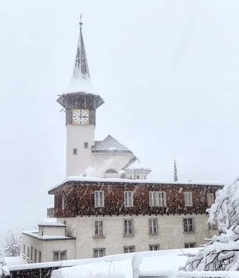 snow covered church tower with clock during winter