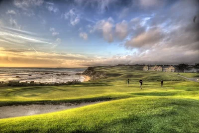 coastal golf course at sunset with players