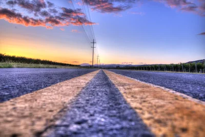 empty road at sunset with power lines