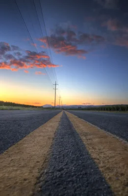 empty road stretching toward sunset mountains