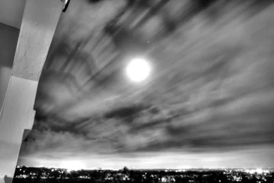 night sky with clouds and city lights below