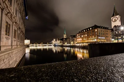 european city waterfront at night with church towers