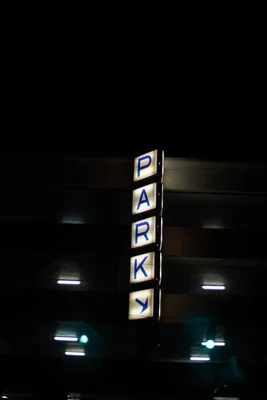illuminated parking sign against dark night sky