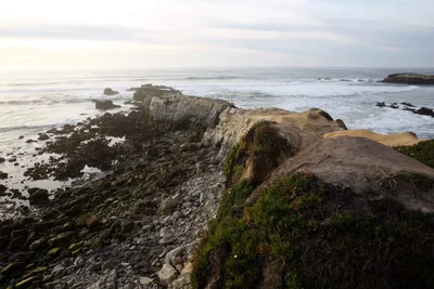 rocky coastline with waves at dusk