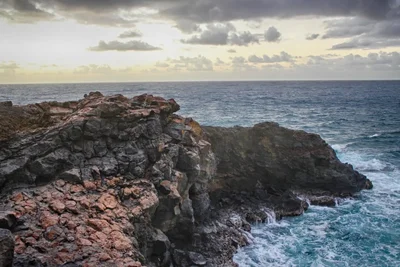rocky coastline with waves at dusk