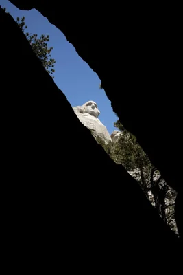 mount rushmore viewed through rock opening