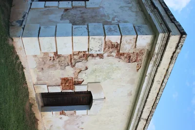 deteriorating swimming pool with damaged tiles and rust stains