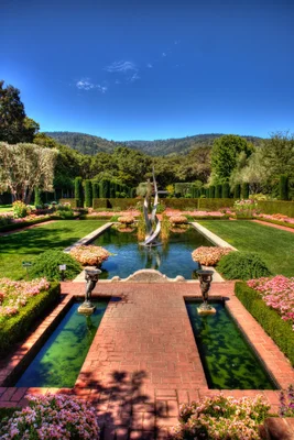 formal garden with fountain and mountain backdrop