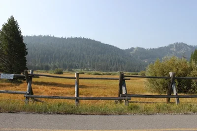 wooden fence along mountain valley road