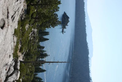 mountain lake with evergreen forest and rocky shore