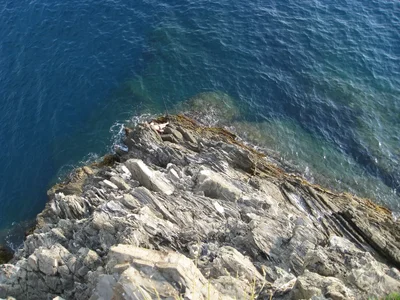 rocky outcrop meets deep blue ocean water