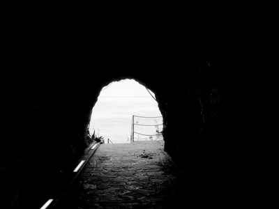 tunnel exit overlooking water with railing
