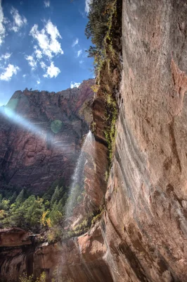 waterfall cascading down red rock canyon walls