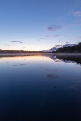 misty lake at twilight with forest silhouette
